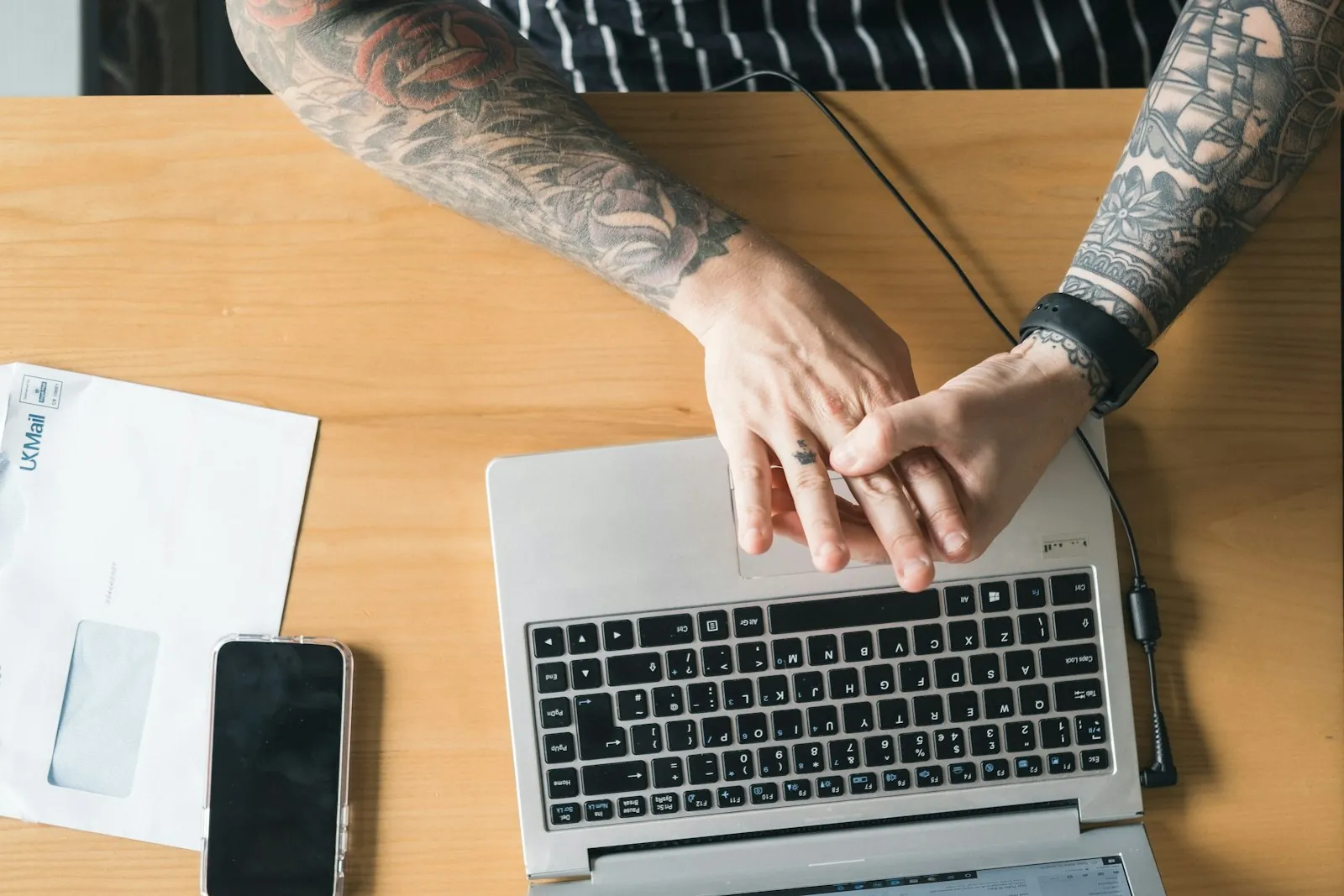 تاجر يعمل على حاسوب محمول إلى جانب هاتفه